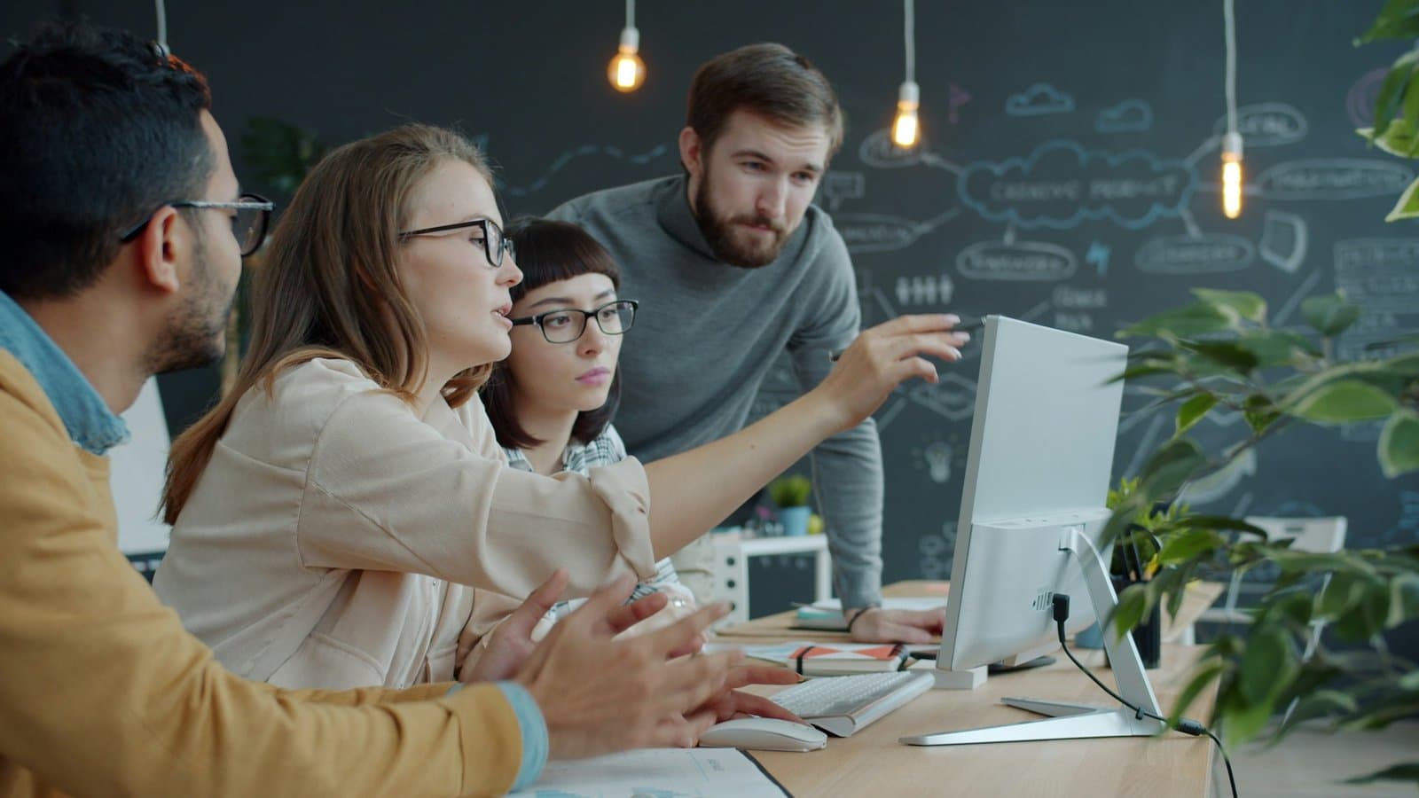 Team collaborating around a laptop